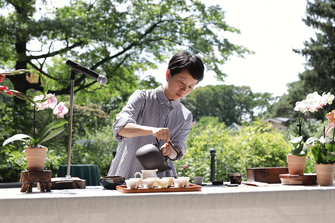 Elena Liao pouring tea Queens Botanical Garnden.