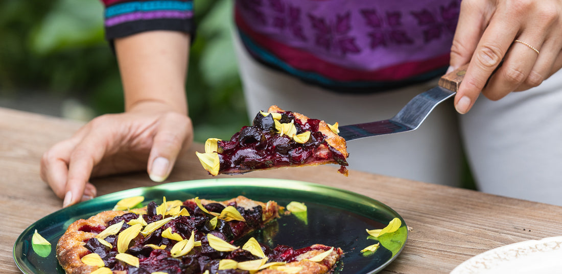 Serving a slice of fruit tart with yellow petals.