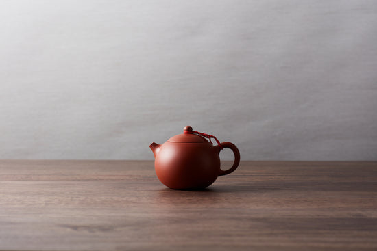 A clay teapot on a wooden surface.