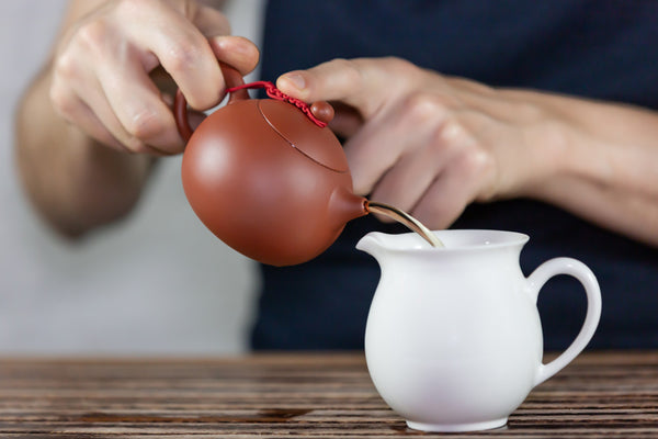 pour tea into pitcher