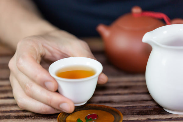 hand holding full teacup