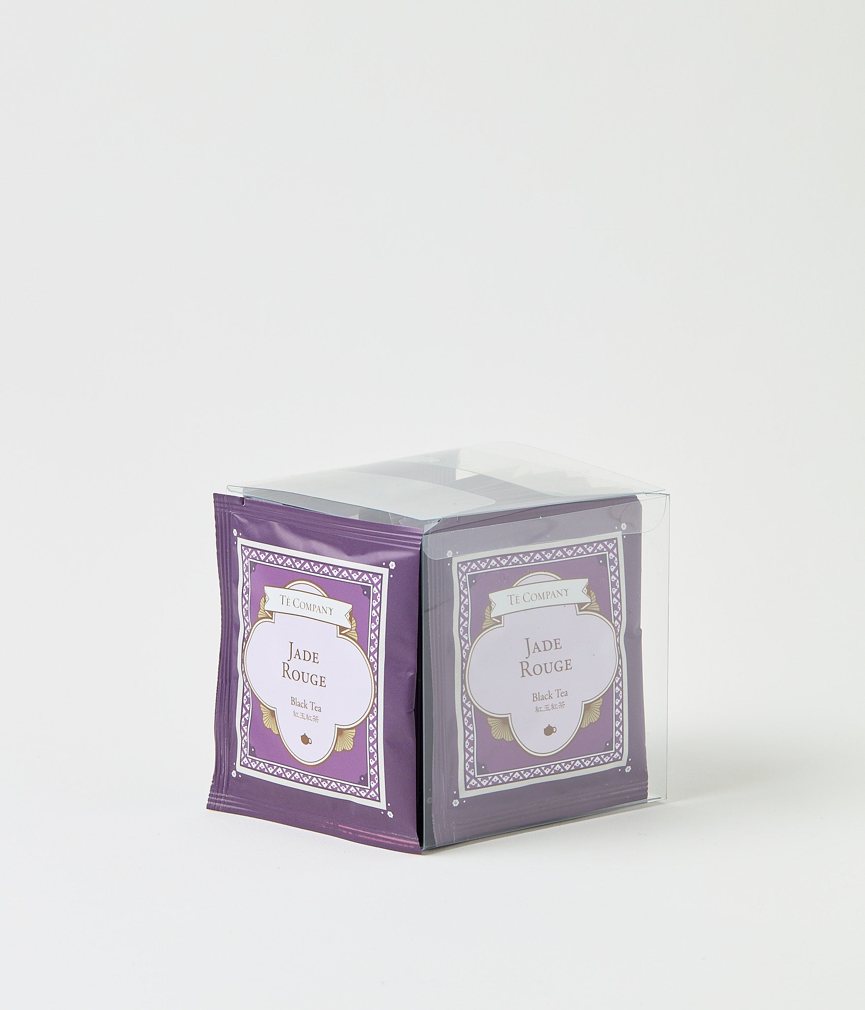 Stack of Te Company Jade Rouge black tea packets packaged in a clear plastic box against a white background.