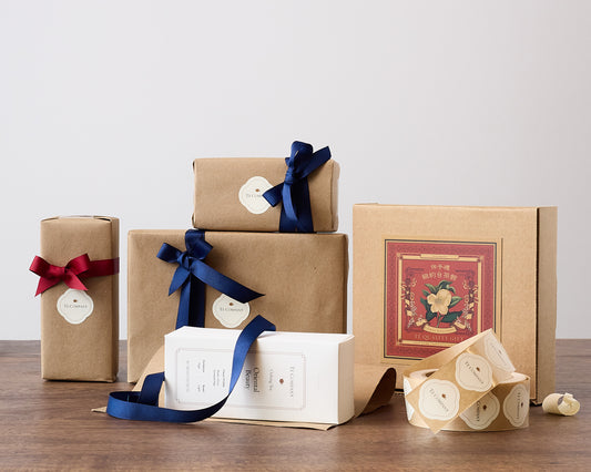 Gift-wrapped tea packages with ribbons and decorative boxes.