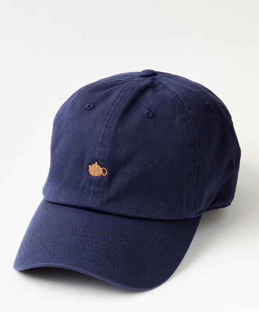 Navy blue baseball cap with a small embroidered golden teapot design on the front.