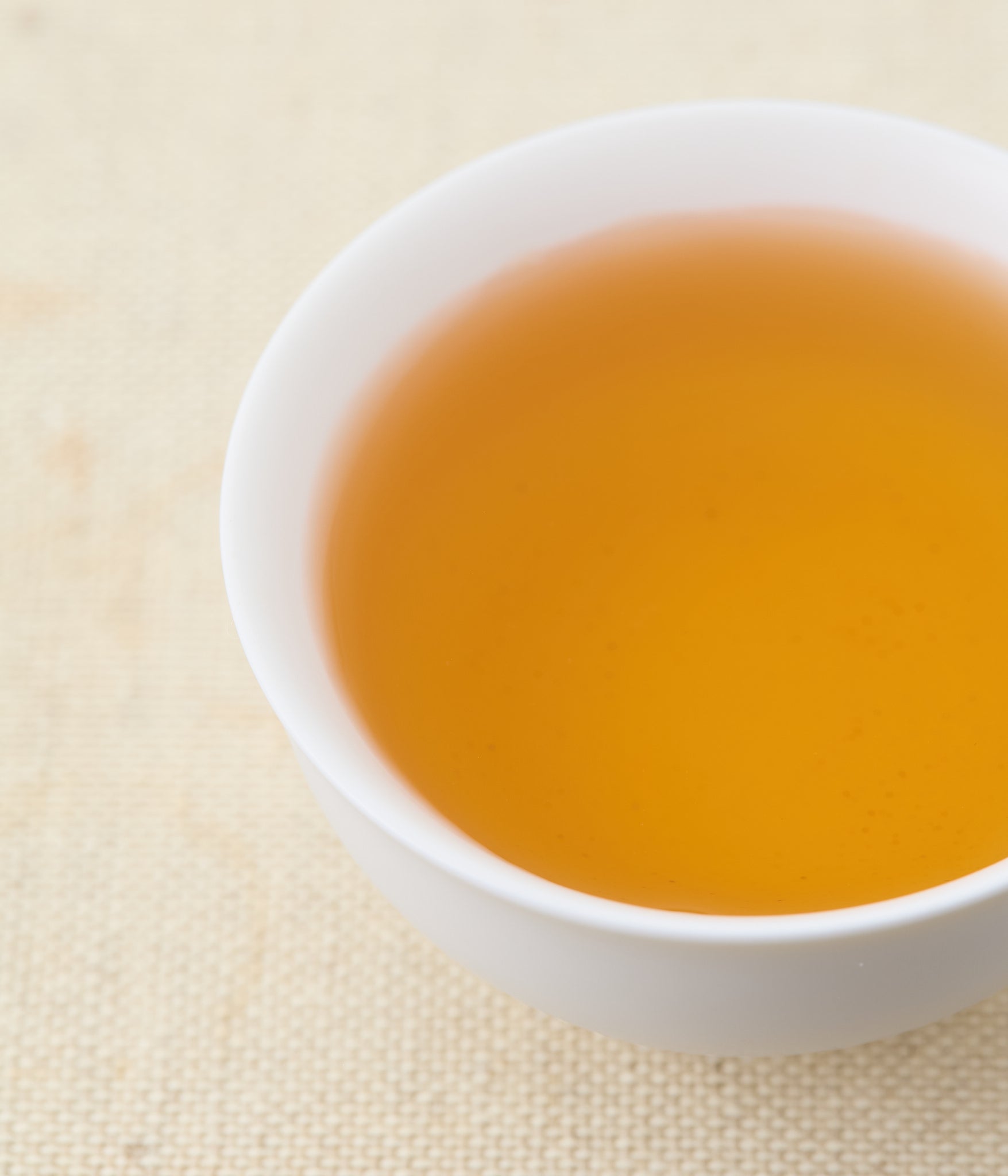 Golden amber liquor of Honeyed Black tea in white ceramic cup