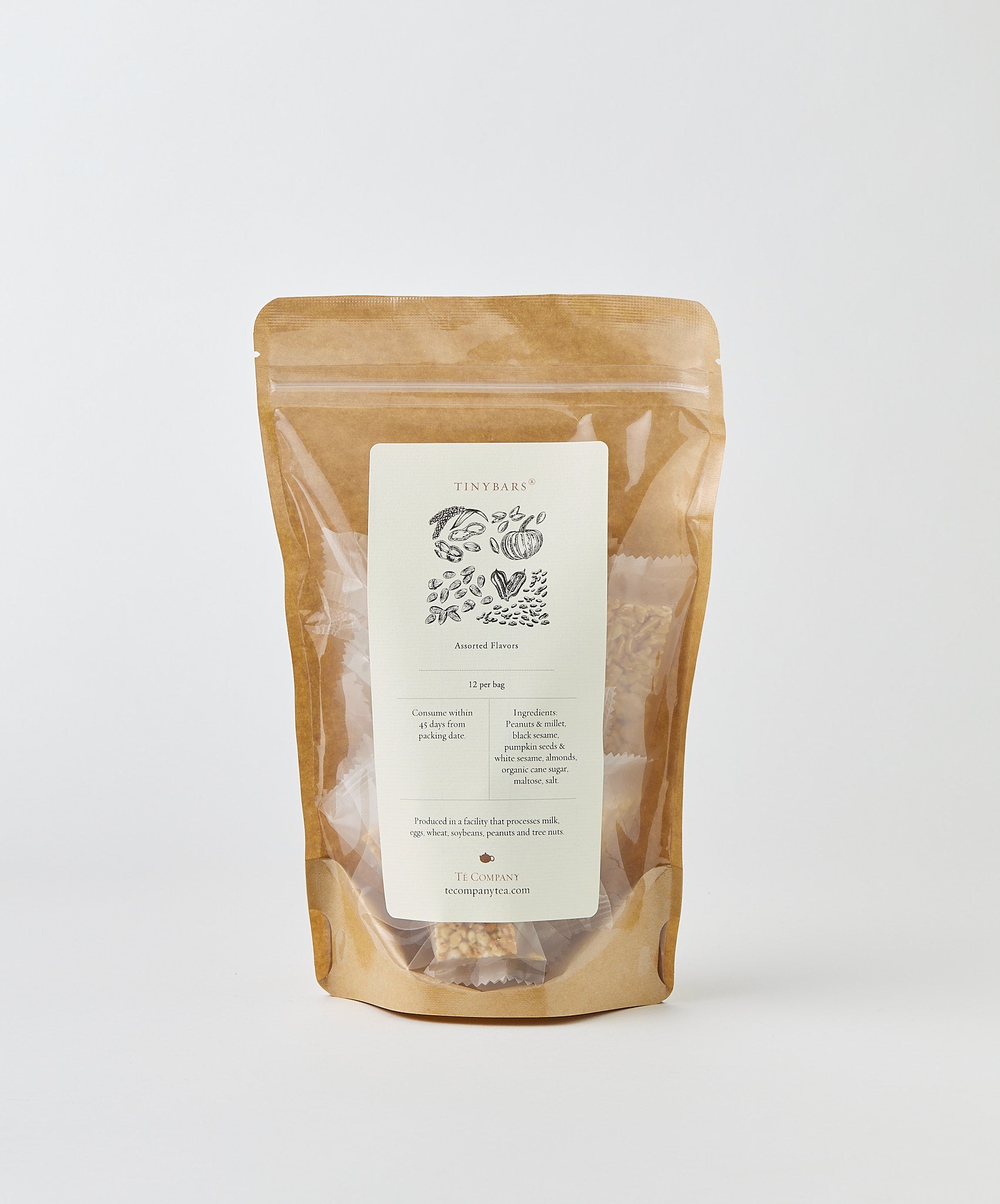 A bag labeled Tiny Bars, assorted flavors, with an illustration of nuts and grains on the front, set on a white background.