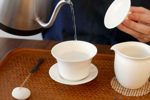 Warming a gaiwan with hot water before steeping tea.