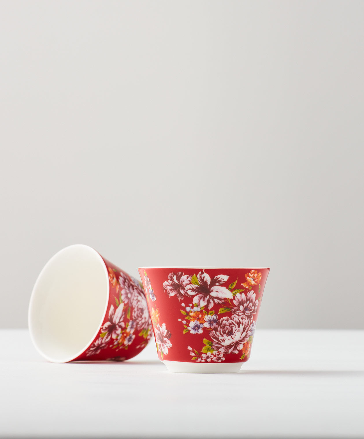 Red floral cups, one upright and one lying on its side
